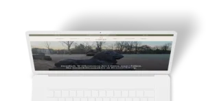 Laptop mit geöffneter Webseite einer Immobilienfirma, auf der ein Löwen-Skulptur vor einer Parklandschaft zu sehen ist, dazu der Text „Herzlich Willkommen bei Löwen Immobilien. Ihr Immobilienmakler in Braunschweig.“ Die Webseite zeigt ein klares, responsives Webdesign mit Menüleiste oben.